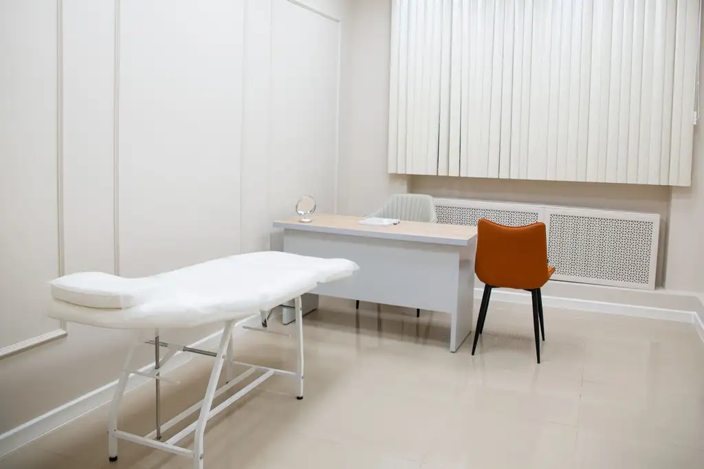 A treatment couch and consulting desk in a clinic room